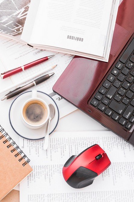 workdesk were is seen a mouse, keyboard and cup of coffe
