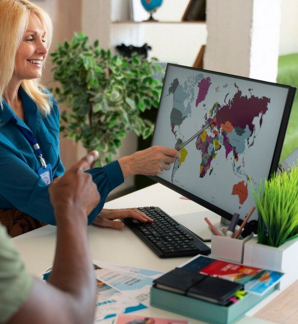persons looking at a pc which shows the world map